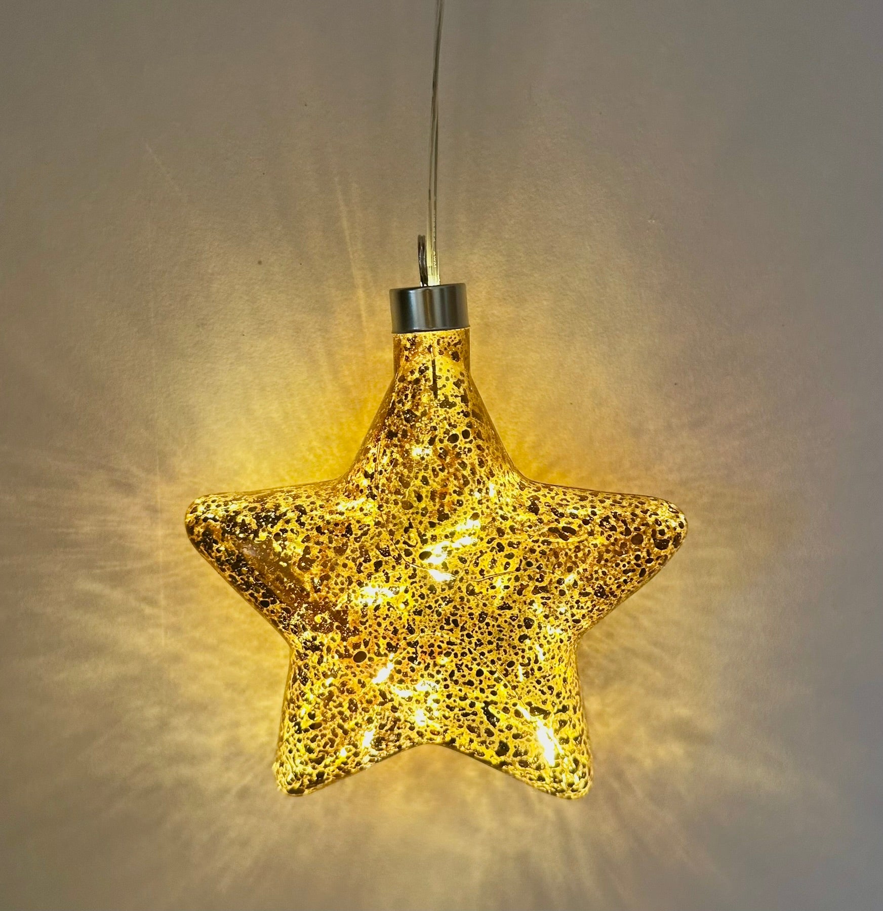 Illuminative bronze star glass hanging decoration glowing with warm festive light, perfect Christmas tree or home décor piece and elegant gift for her.