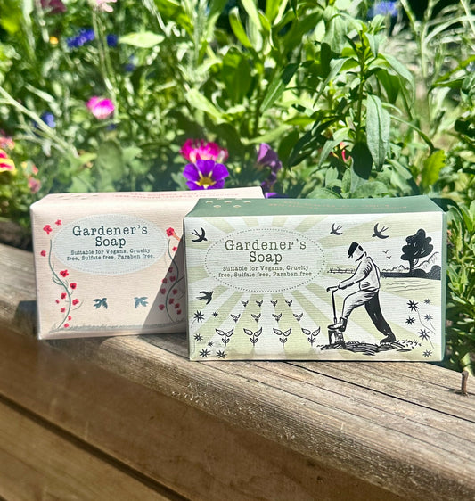 Two bars of 'Gardener's Soap' on a wooden surface with a natural background
