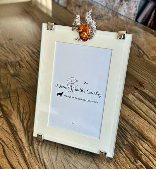 a glass photo frame featuring a metal red squirrel motif