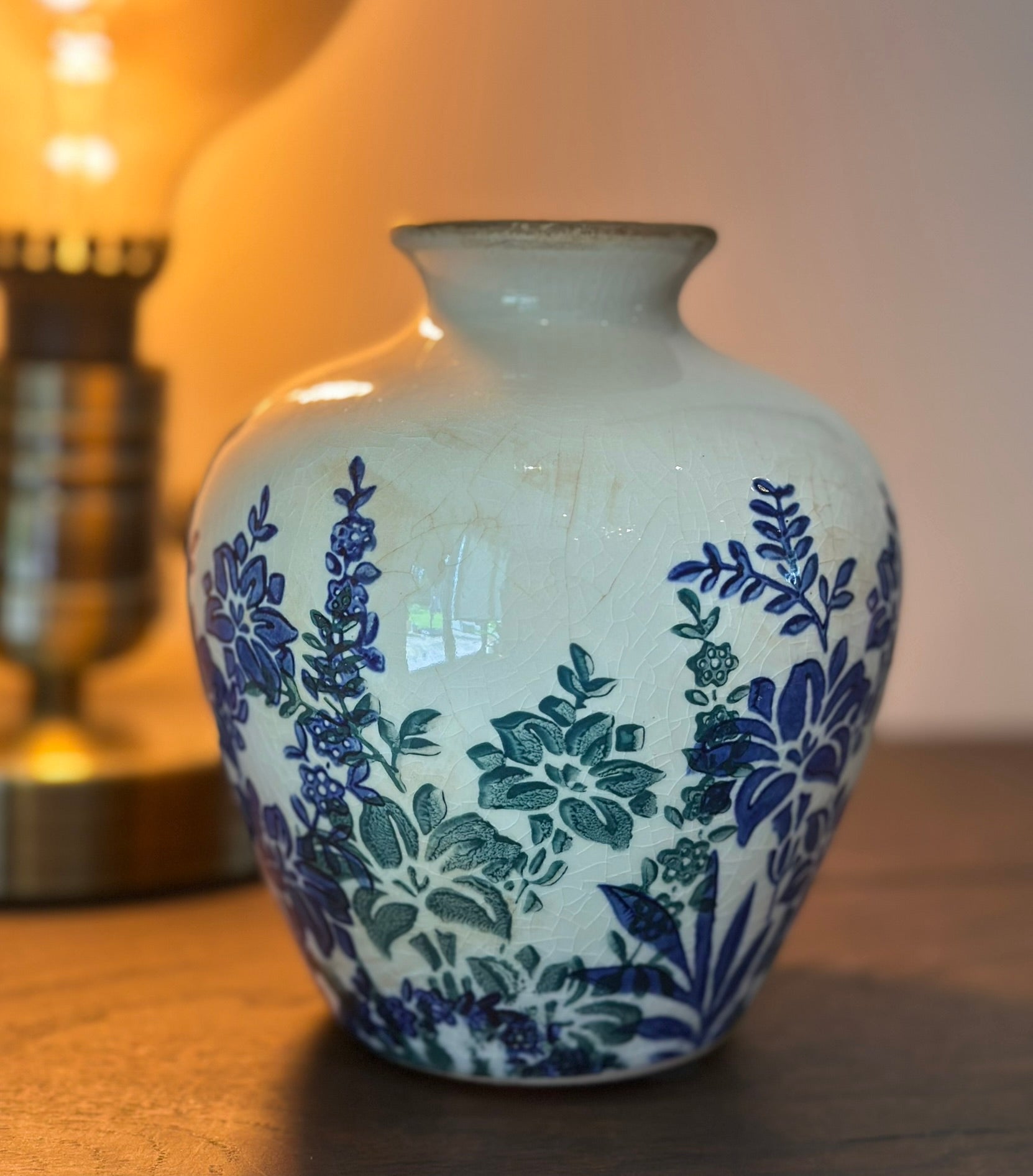 White vase with blue floral patterns on a wooden surface