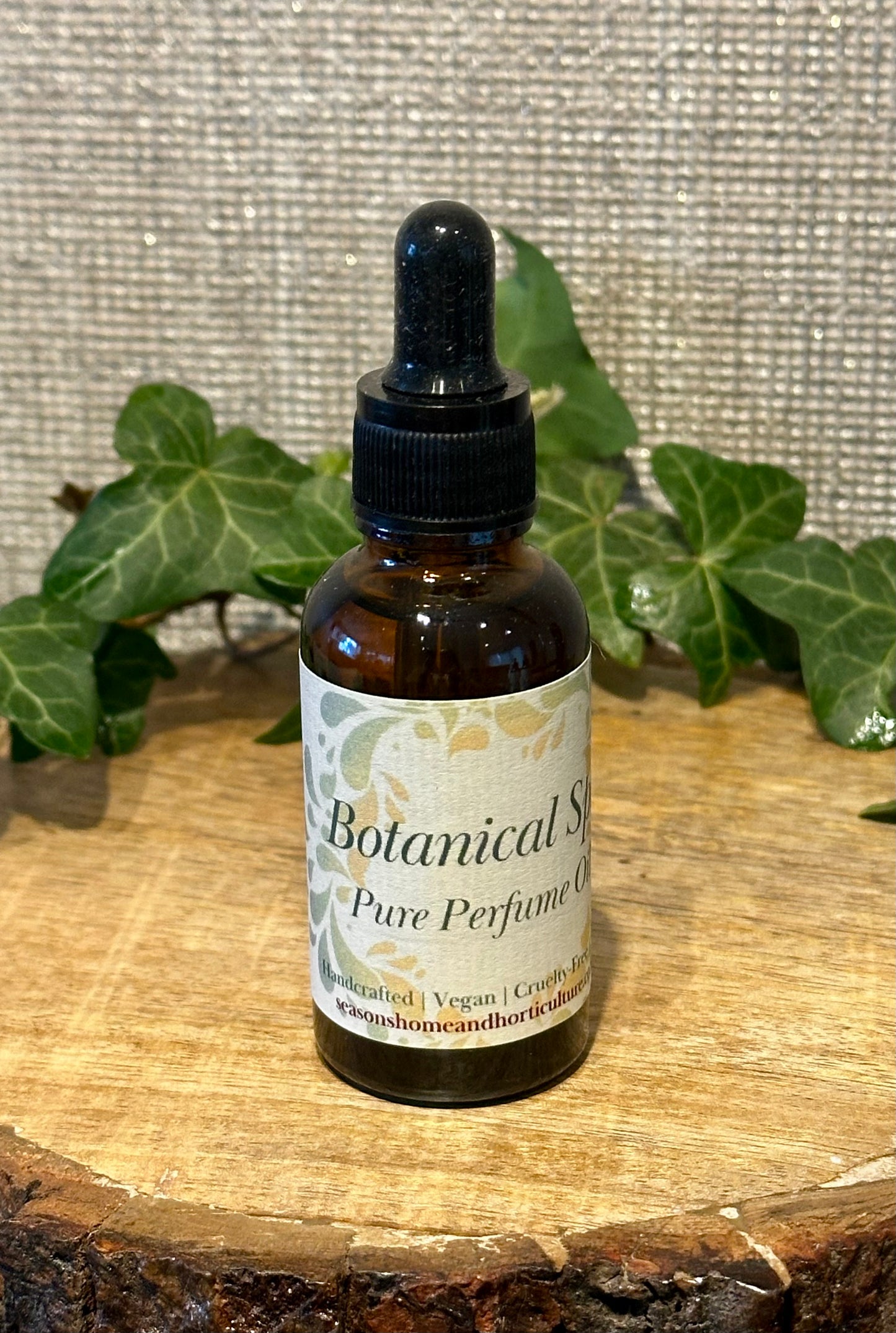 Botanical spa perfume oil with pipette in a glass bottle, featuring lemongrass, patchouli, and ginger notes for a fresh herbal home fragrance ambiance