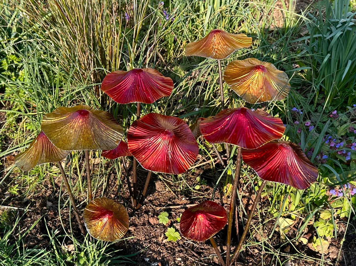 Colourful metal mushroom garden stakes displayed in flower bed outdoor garden decor for borders and landscaping