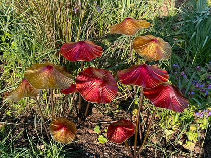 Colourful metal mushroom garden stakes displayed in flower bed outdoor garden decor for borders and landscaping