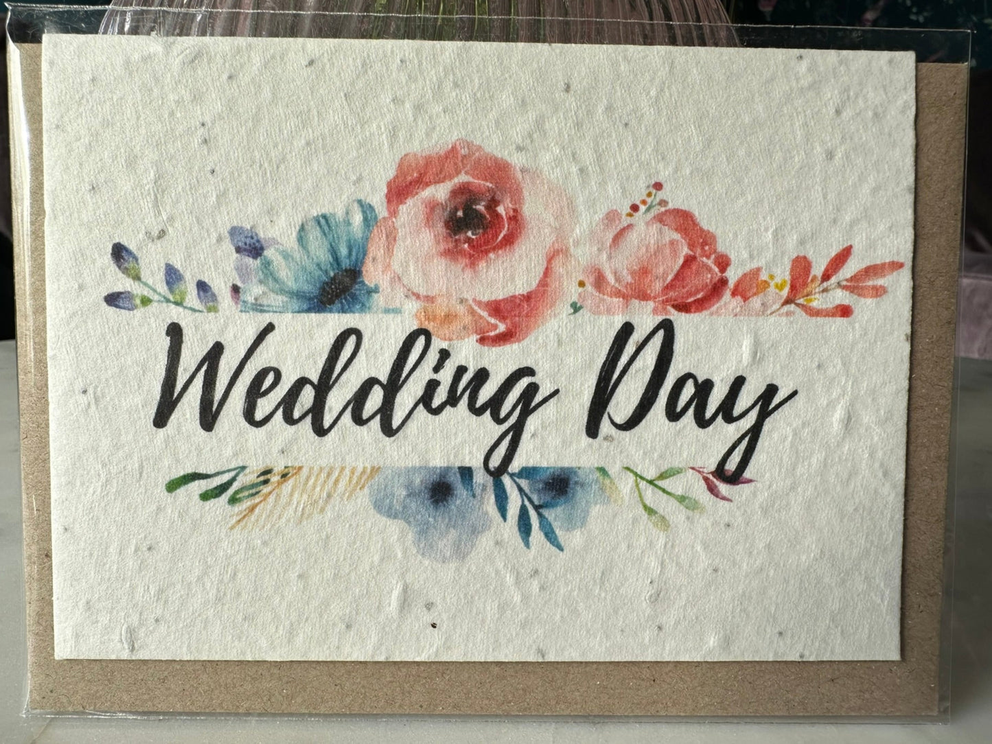 a wildflower seed card with 'wedding day' written in script, bordered by flowers in a watercolour style. 