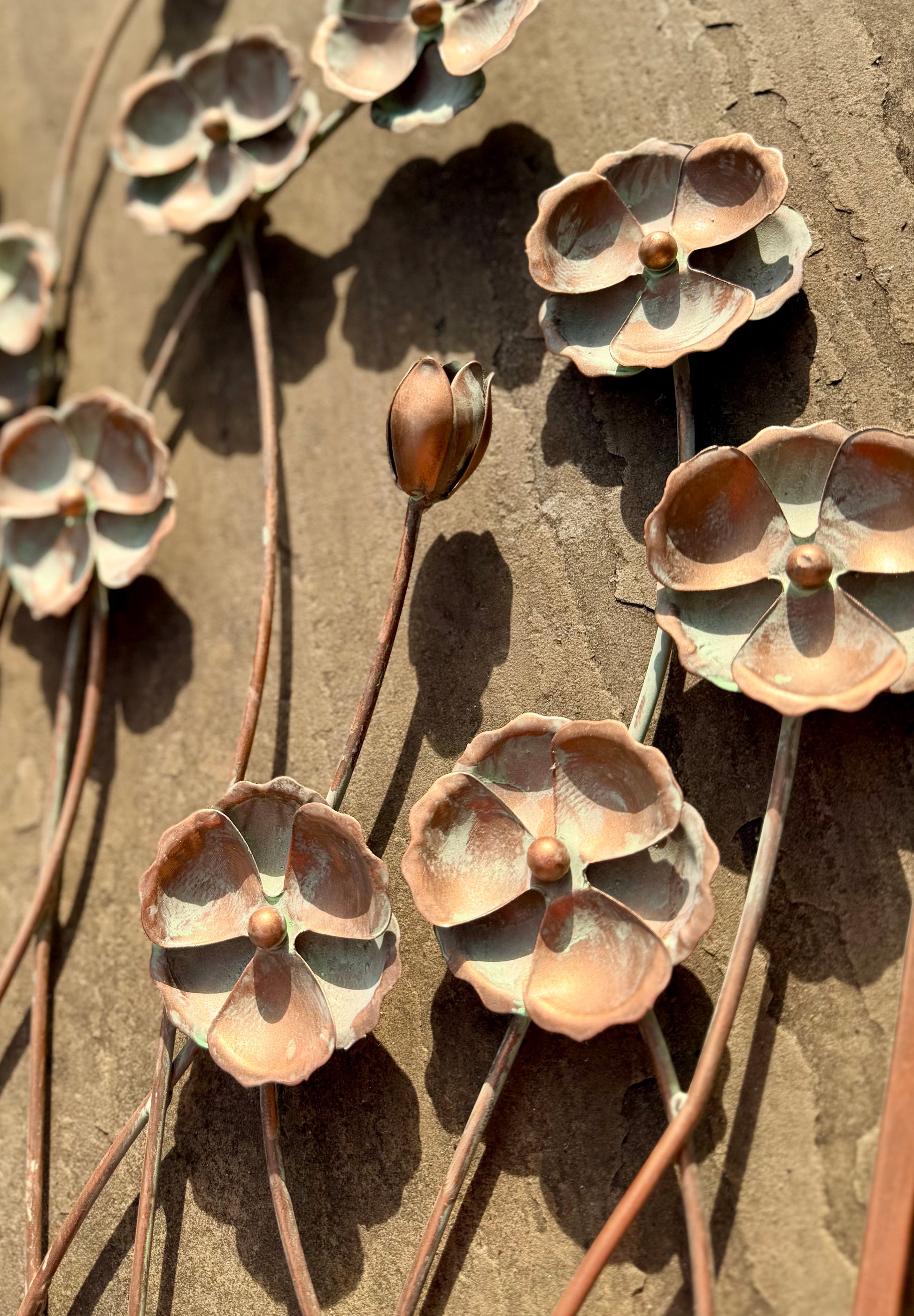 Rustic metal wall decoration featuring a cornflower motif for cottage garden styling