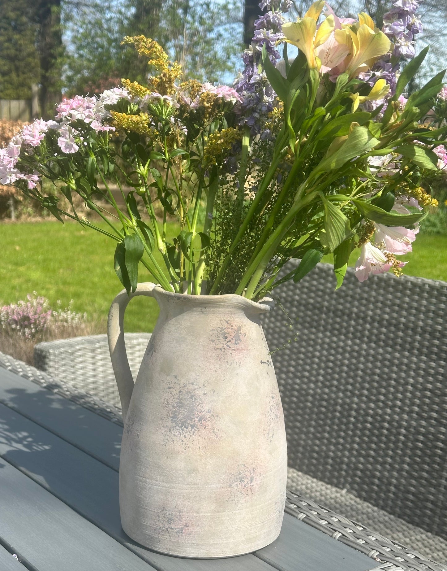 a large stoneware vase/jug with flowers in