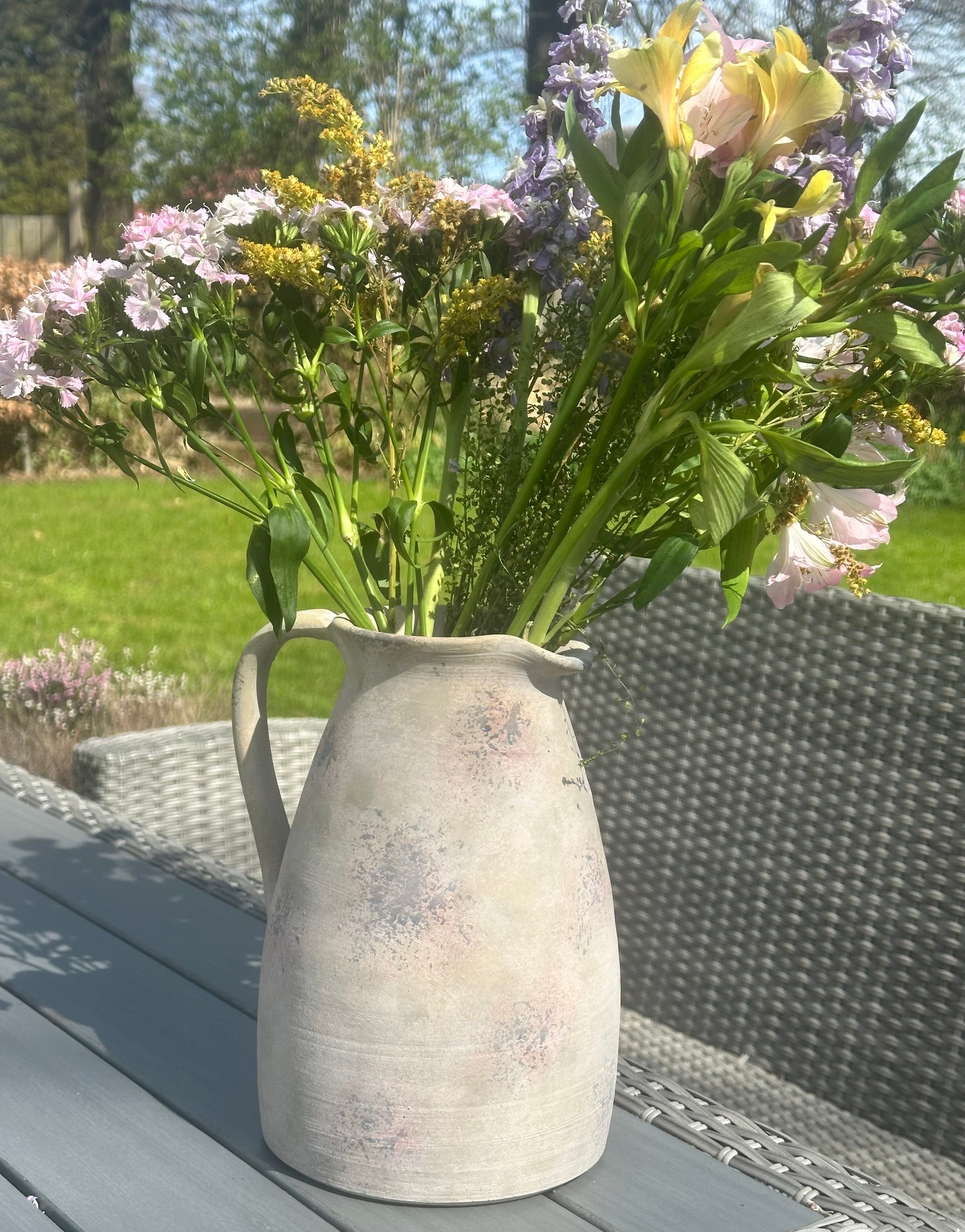 a large stoneware vase/jug with flowers in