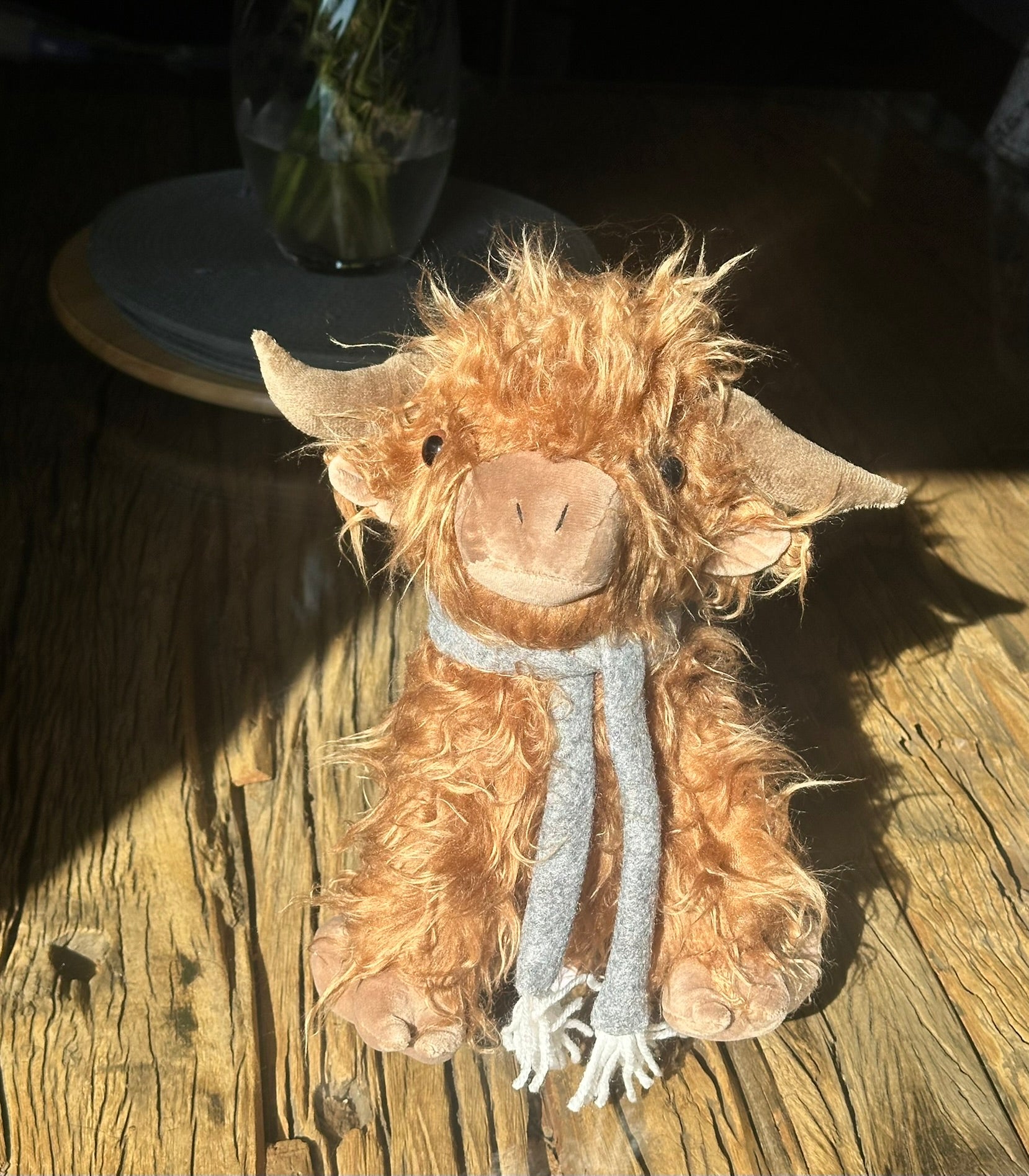fluffy highland cow doorstop with horns and a scarf brown