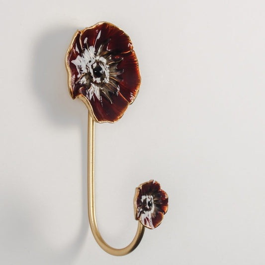 Gold home decor hook with a red enamel poppy on a light gray background