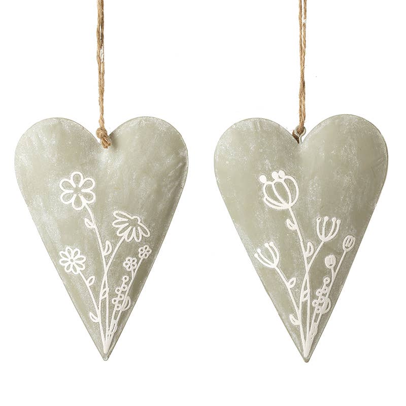 Two heart-shaped decorations with floral patterns hanging on a white background