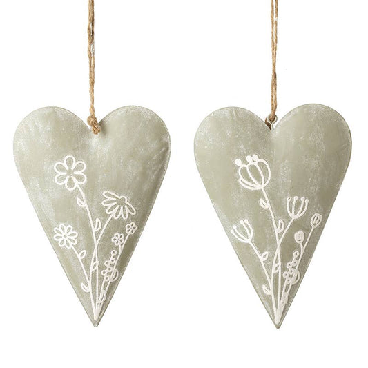 Two heart-shaped decorations with floral patterns hanging on a white background