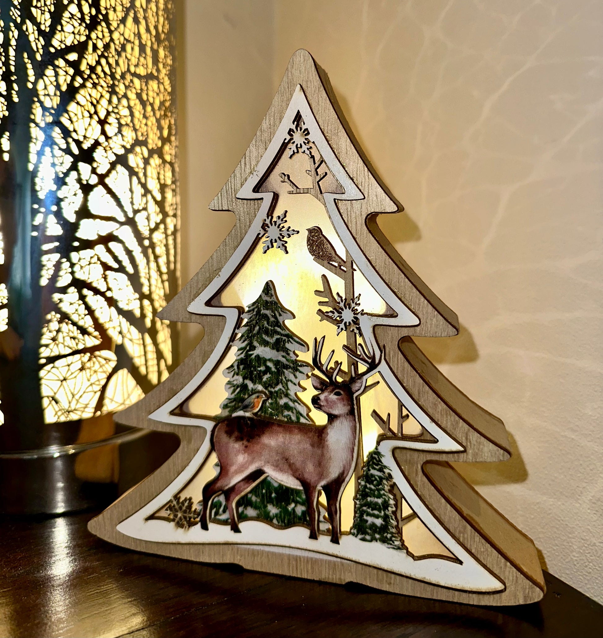 Wooden Christmas tree decoration with deer, robin and snowflakes, illuminated from within.