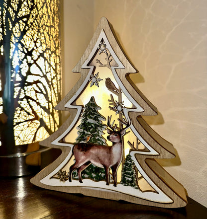 Wooden Christmas tree decoration with deer, robin and snowflakes, illuminated from within.