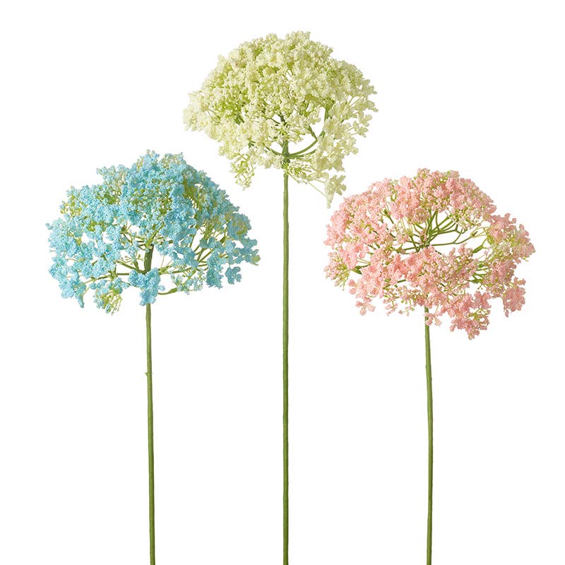 Three artificial flowers in blue, yellow, and pink on a white background