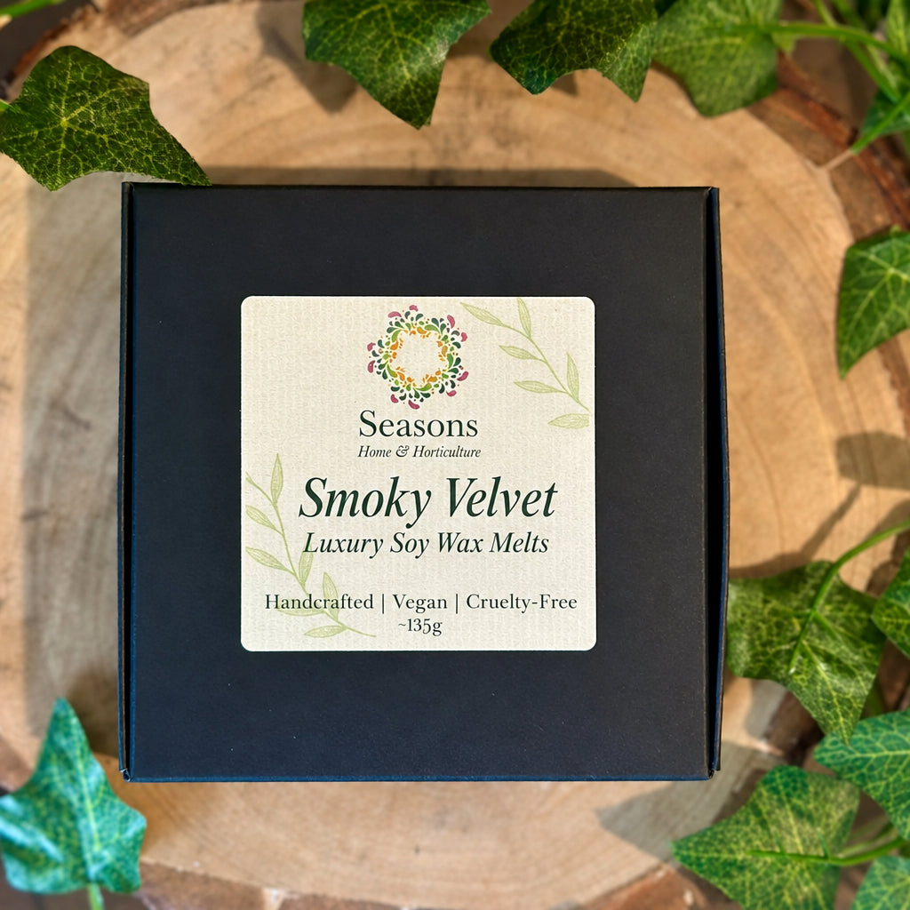 Box of Seasons Smoky Velvet wax melts with a decorative label on a wooden surface with ivy leaves.