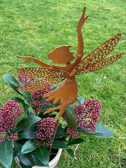 metal fairy garden stake in a bed of flowers