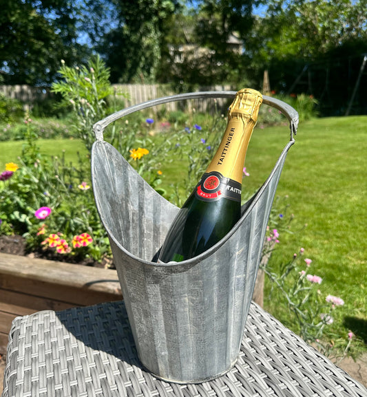 Bottle of champagne in a metal bucket outdoors on a sunny day