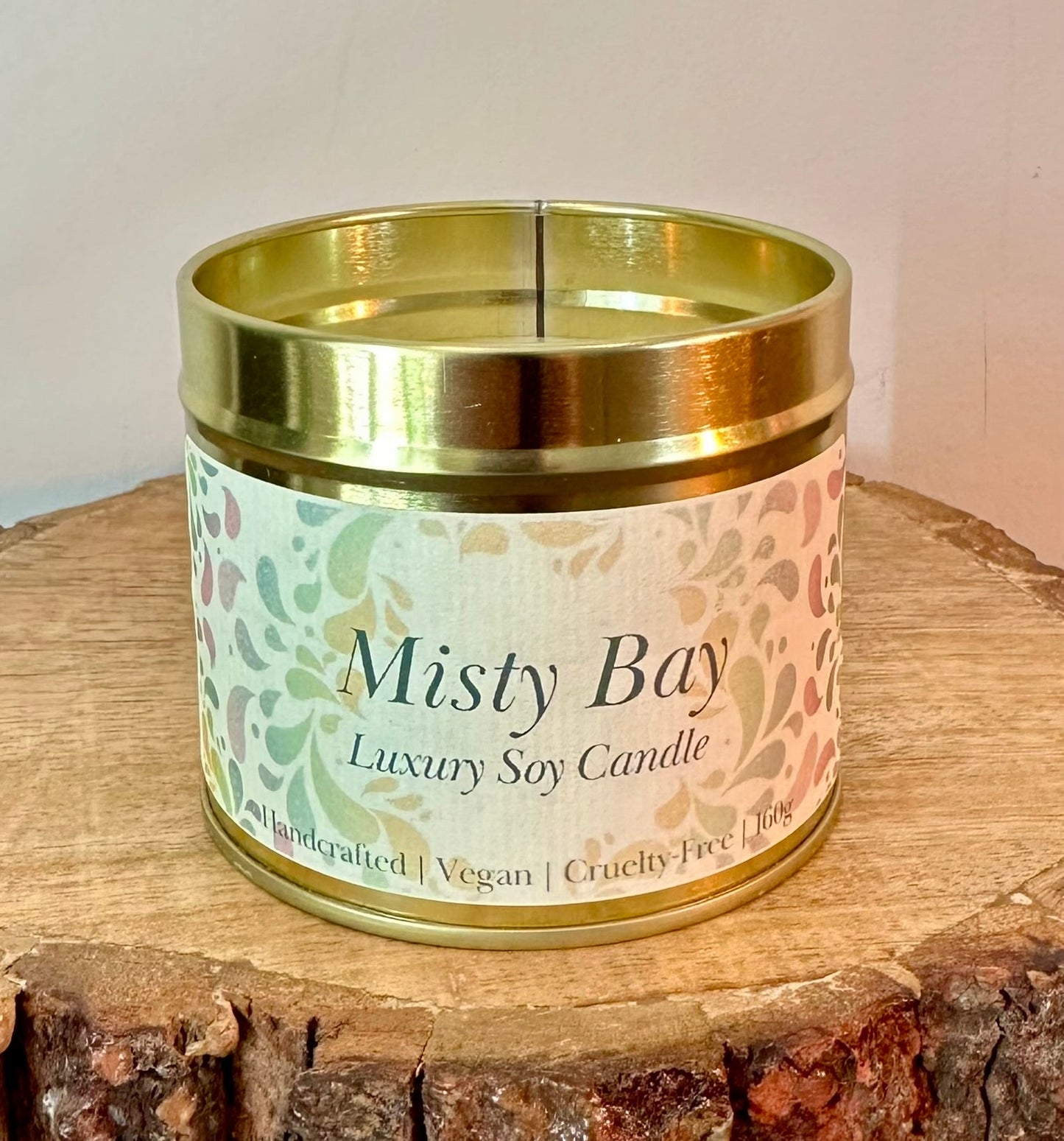 Misty Bay luxury soy candle in gold tin container on wooden surface handmade vegan home fragrance