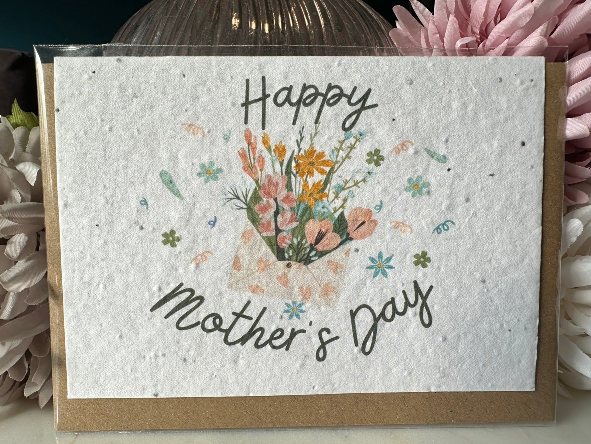 an image of an envelope of flowers bordered with the script of 'happy mother's day' on wildflower seed paper. 