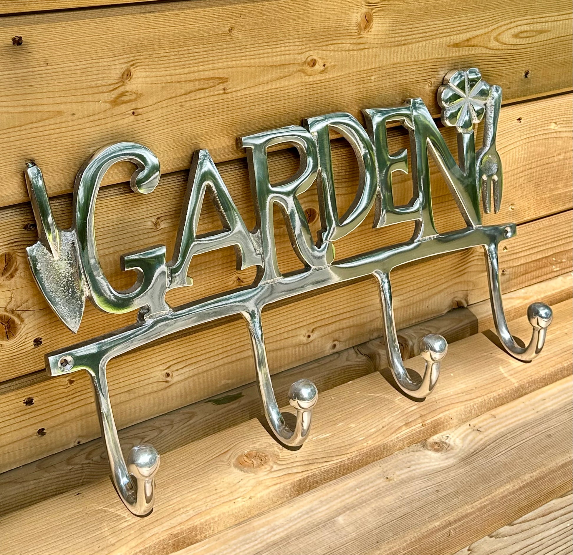 Decorative outdoor wall sign with multiple hooks for garden tools or coats