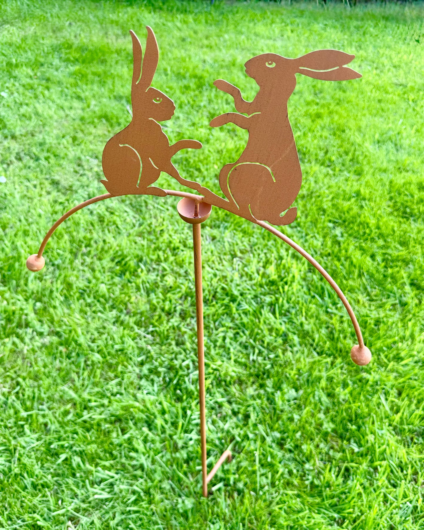 Rustic metal hare garden stake balancer displayed outdoors as decorative garden ornament for lawns and borders