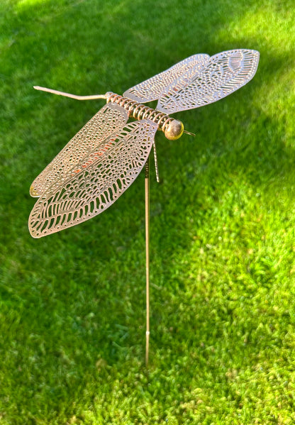 Rustic iron and copper dragonfly garden stake displayed on lawn decorative outdoor garden ornament