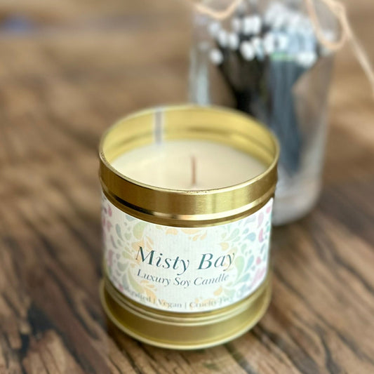 misty bay candle, in a gold tin with lid. 