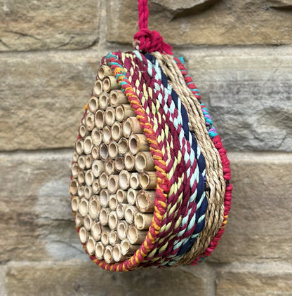 Handmade garden bug hotel using sustainable sari textiles and grass, designed for pollinators and wildlife