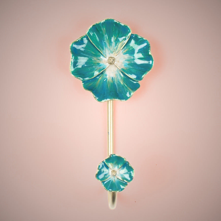 Floral coat hook with teal and gold design on a pink background